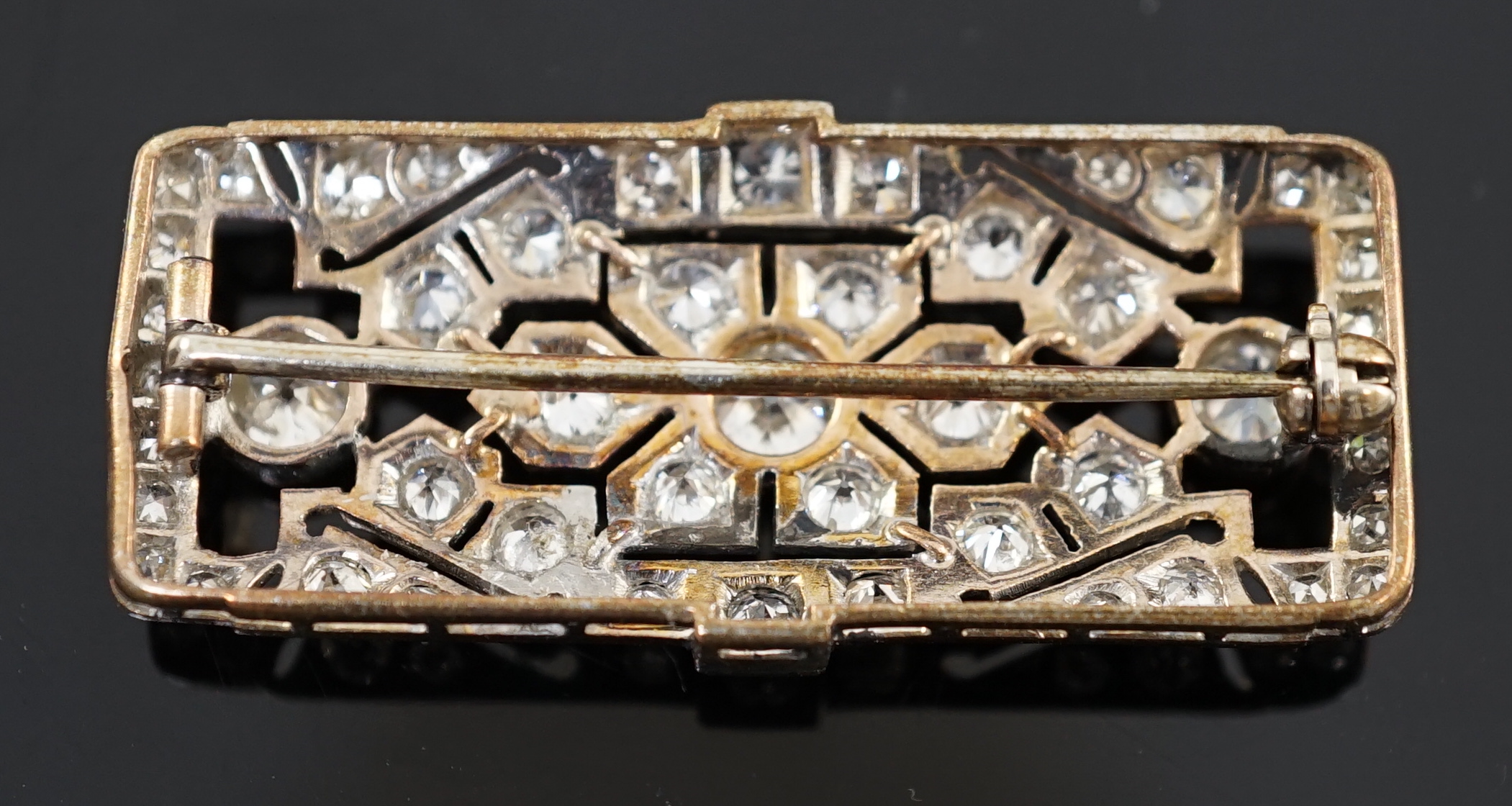 An early 20th century pierced gold and graduated round cut diamond cluster set brooch